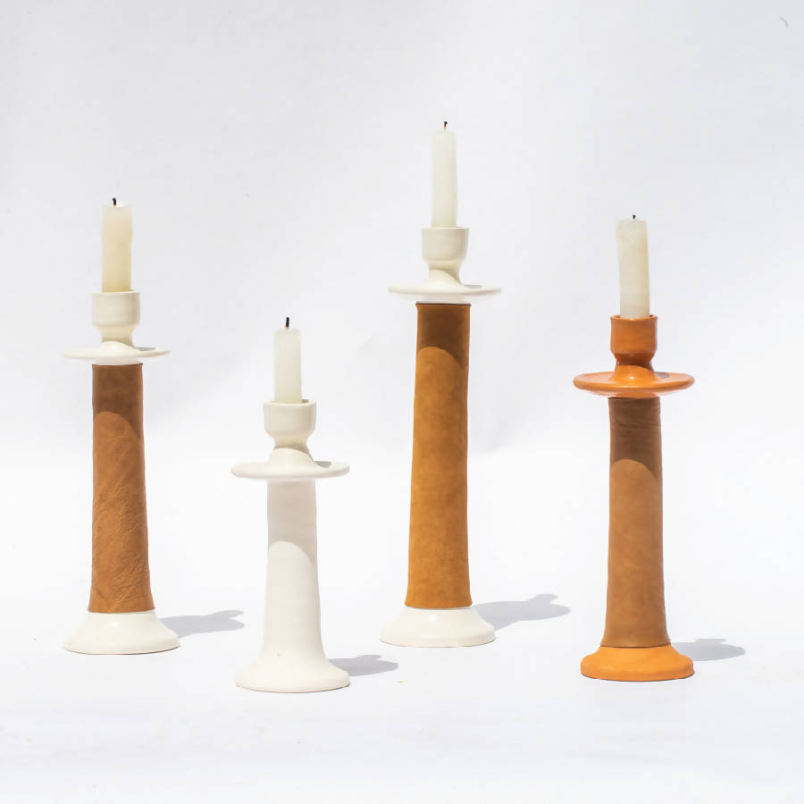 Set of four candle holders with candles on a white background